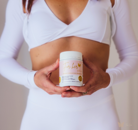 Tara Lori, women’s health coach, presenting For Her probiotic for gut and hormone health — warm and confident lifestyle shot.