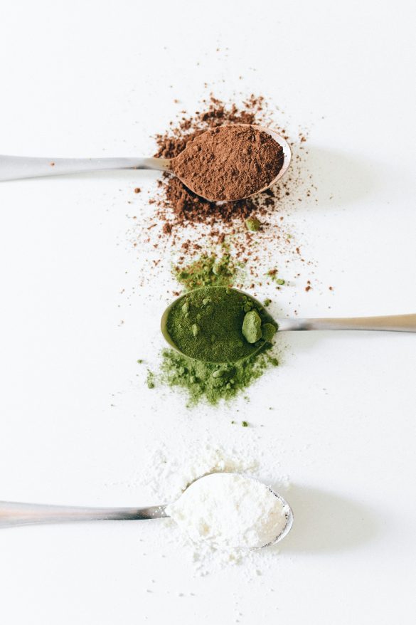 Powder supplements on three teaspoons, illustrating a wholefood, gut-health-first supplement approach for women 35+