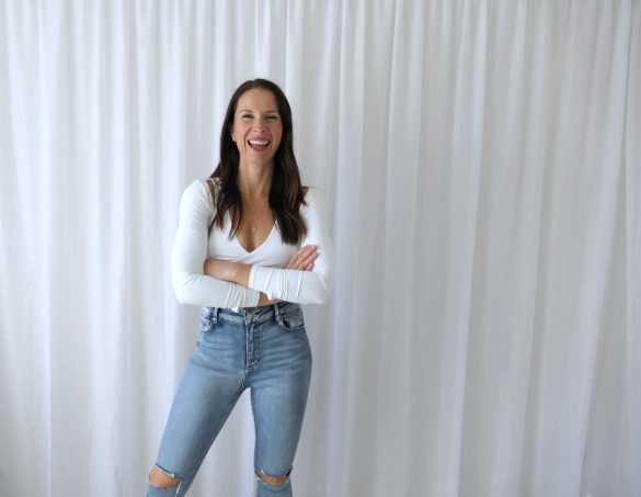 Fit, healthy woman in her 40s smiling outdoors, representing natural hormone balance, nervous system regulation and gut health support for women over 35 through holistic wellness practices.